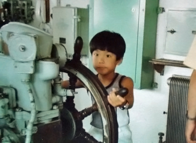 モデルファクトリーハイギヤード代表　渡辺真郎の少年時代。すでに舵輪を握っています。